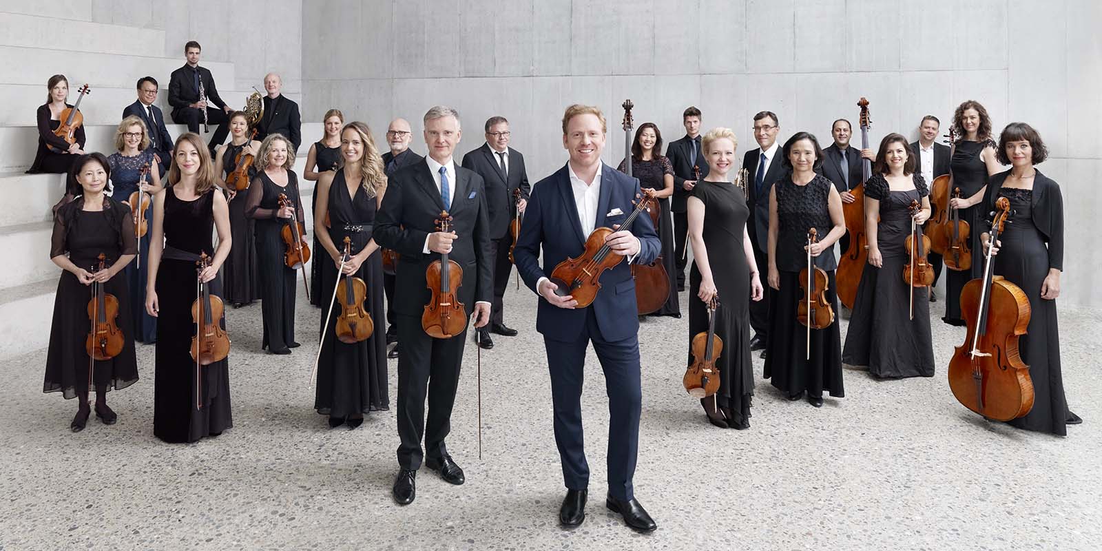 Daniel Hope and Zurich Chamber Orchestra posing with their instruments.