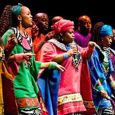 Men and women in colorful robes singing