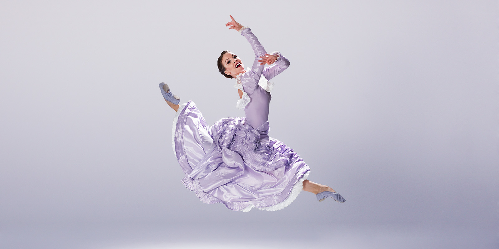 A woman in a purple dress leaps in the air