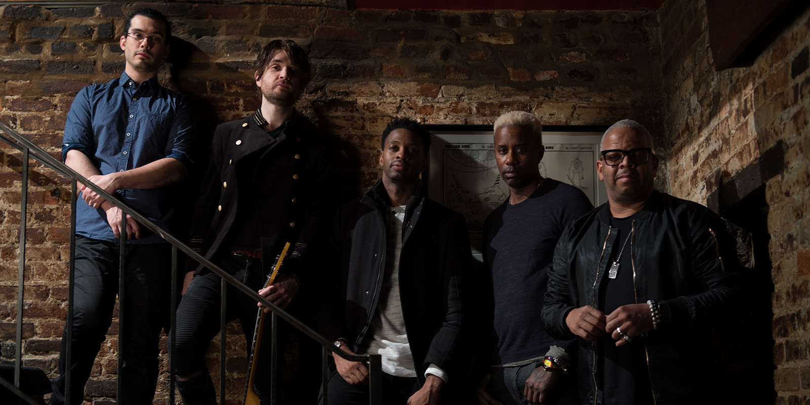 Terence Blanchard and the members of E Collective stand on stairs in front of a brick wall
