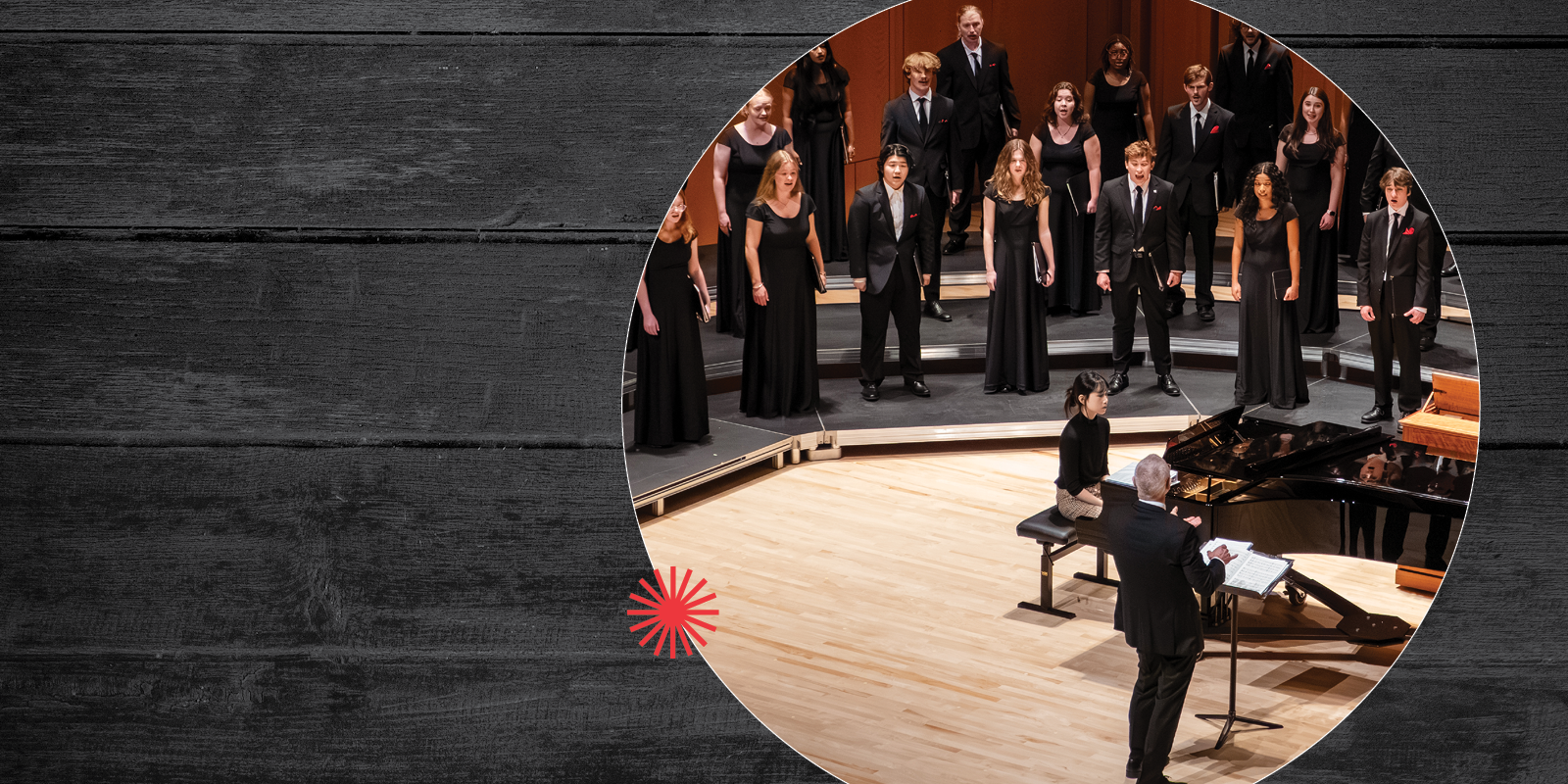 A choir in formal black attire performs on stage, directed by a conductor standing at a piano. The scene is framed by a circular cutout on a wooden background.